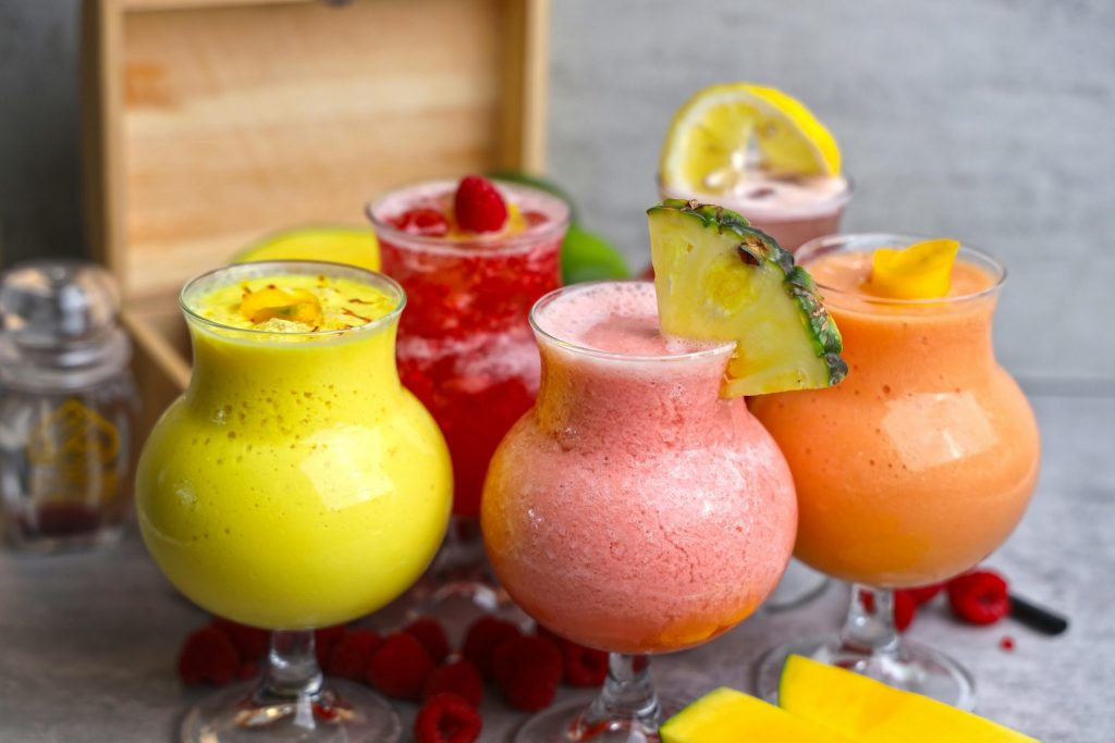 Eine lebendige Auswahl an fruchtigen Mocktails mit frischen Garnituren, perfekt für die Erfrischung im Sommer.