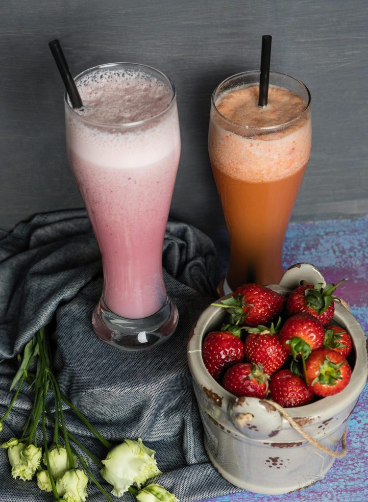 Draufsicht auf Erdbeer-Smoothies in Gläsern mit frischen Erdbeeren, perfekt für einen gesunden Lebensstil.